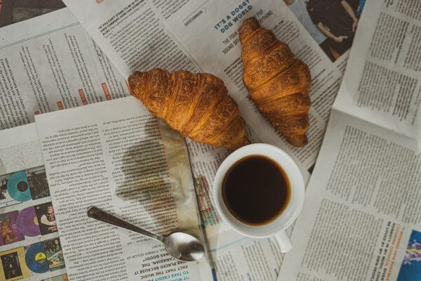 café et croissant sur un journal