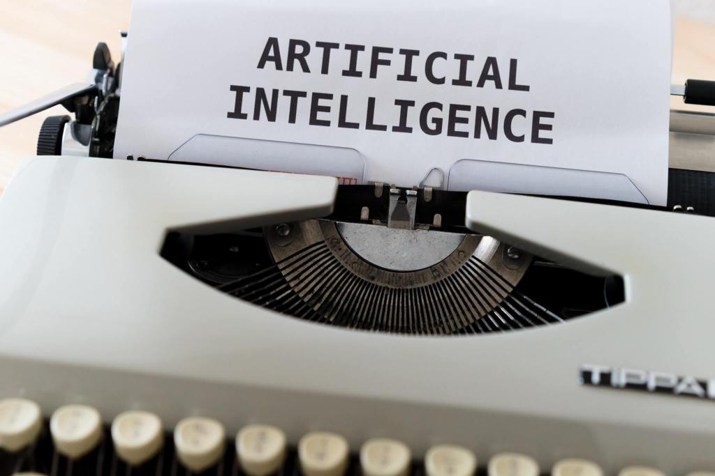 Machine à écrire avec une feuille dedans sur laquelle il est écrit "Artificial Intelligence"